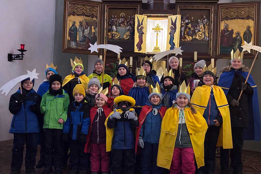 Die 20 Sternsinger und Strenensingerinnen vor dem Altar in Booser Kirche